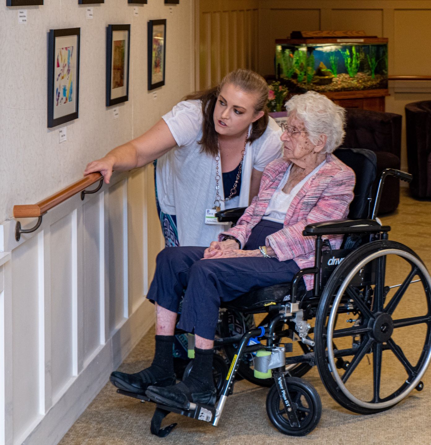Caregiver pointing out something to a senior in a wheelchair