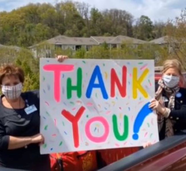 Workers with a thank you sign