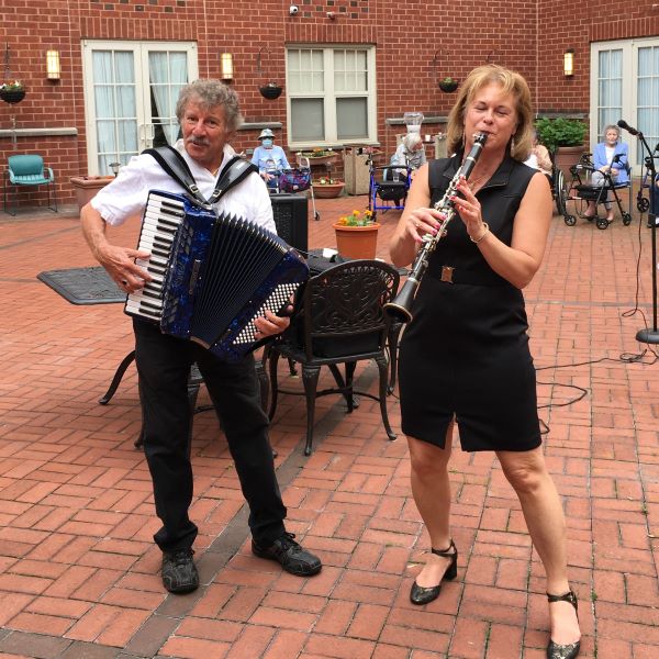 A man playing the accordion with a woman playing the clarinet