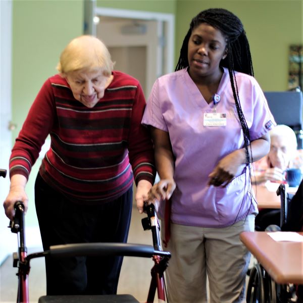 Senior woman with a walker being assited by her caregiver