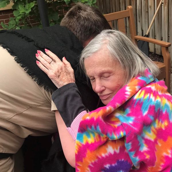 Senior woman being comforted by her caregiver